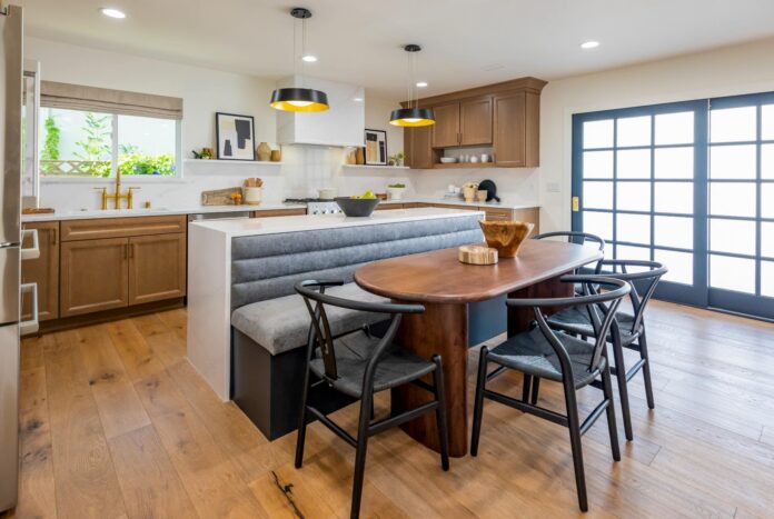 Detailed wood shaker door kitchen cabinets with indigo colored island cabinets and white quartz waterfall countertops