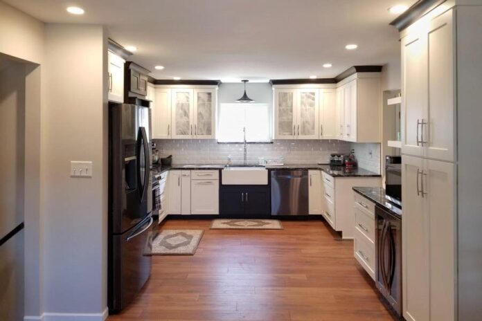 u-shaped kitchen with white cabinets, black molding and pantry storage