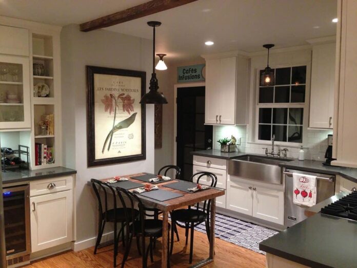 Burbank, California, remodeled kitchen has white Shaker cabinets, built-in desk and hutche, vintage table and chairs and oiled black pendant lamps