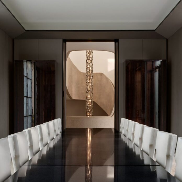 Dining room facing doorway that frames a chandelier