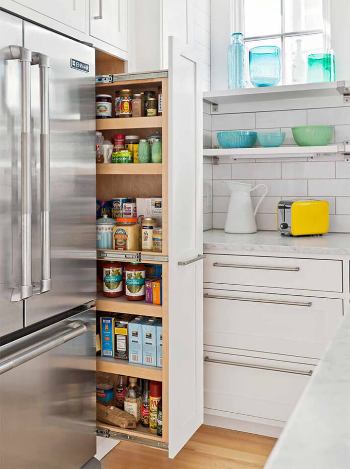 White kitchen featuring a kitchen slide-out pantry next to the refrigerator.