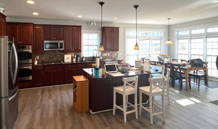 An Avid Baker Designs a Huge Island in His L-Shaped White Kitchen