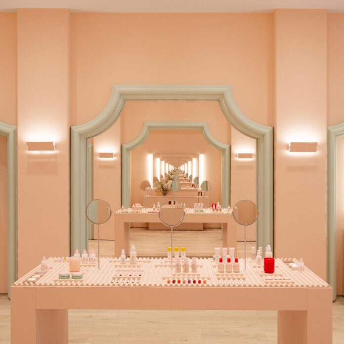 Infinite mirror reflections in pale pink Glossier store