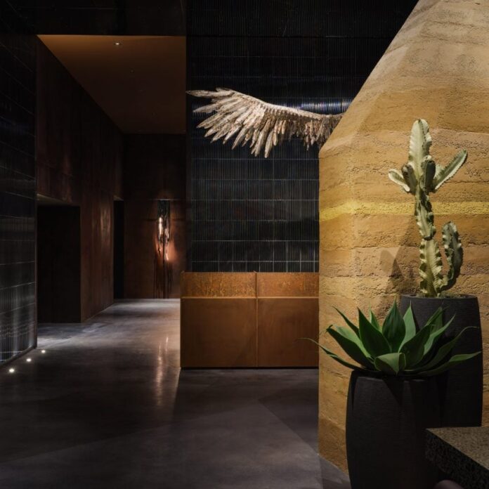 Moxy hotel lobby in LA with rammed earth wall and owl wing