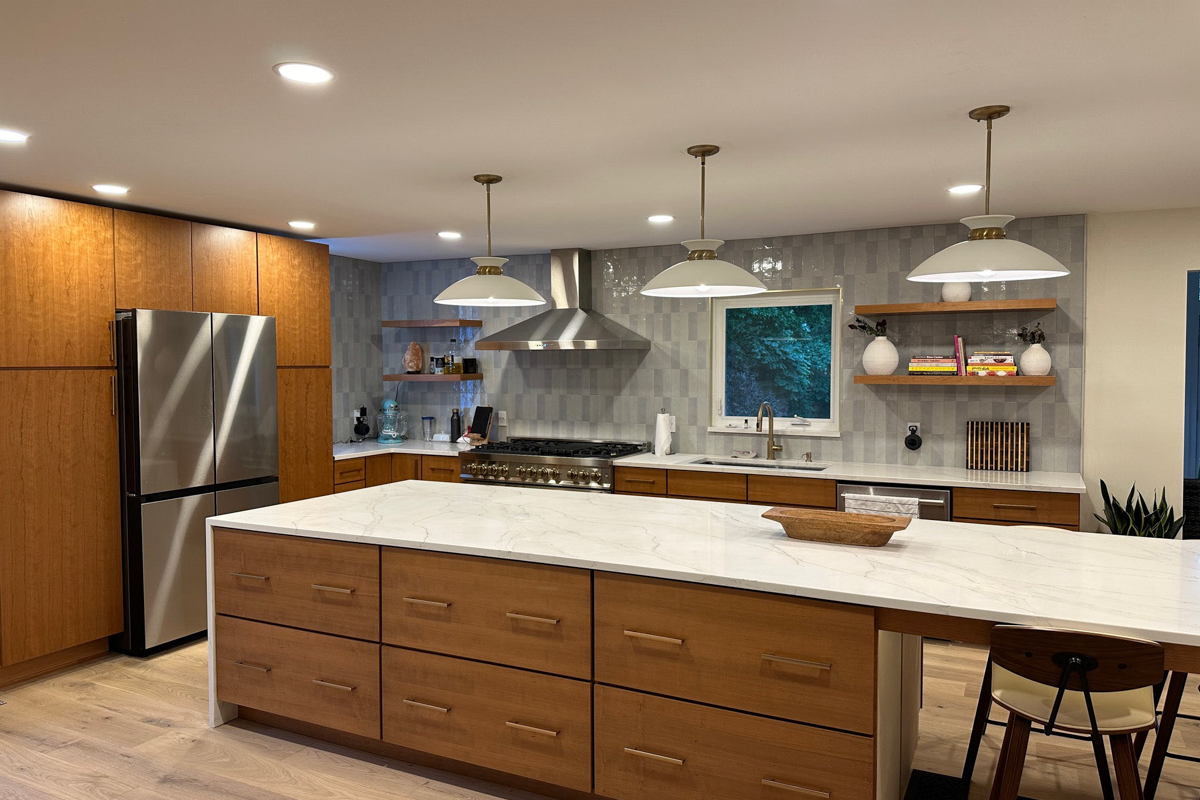 Mid-century modern kitchen with cherry slab door cabinets with a stainless steel kitchen hood, massive island with seating and marble imitation quartz countertops