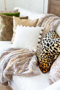 A collection of textured and patterned pillows on a sofa in a fall decorated living room.