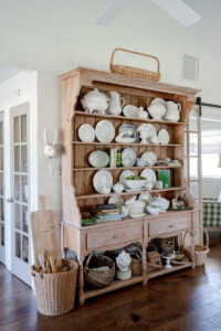 My Little White Barn's pine hutch filled with white serveware and green accents.