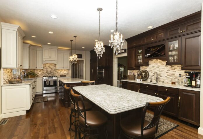 Traditional raised panel kitchen with main area in cream paint and two islands with buffet and refrigerator surround in darker cherry finish