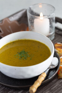 a bowl of creamy cabbage soup that is made with all veggies and broth.