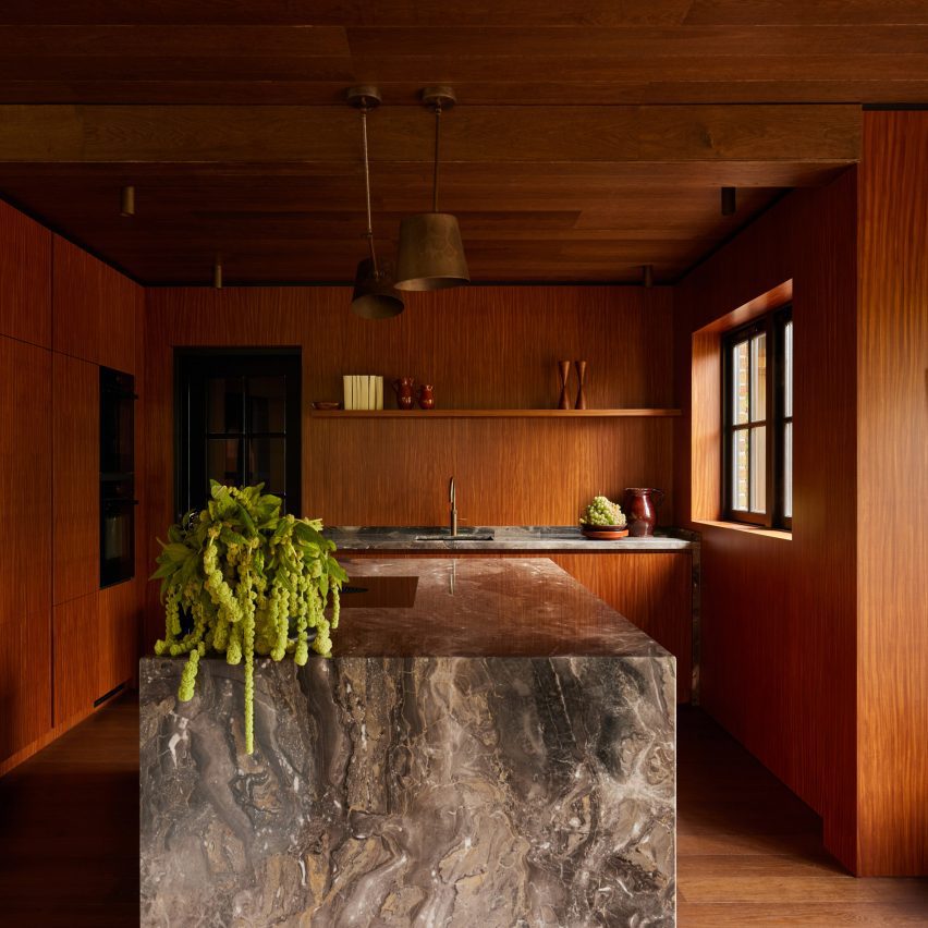 Kitchen interior by DAB Studio with timber walls and a marble kitchen island