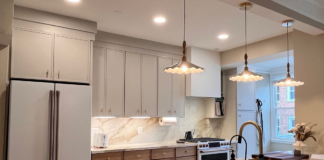 Thin shaker kitchen cabinets with creme upper cabinets and medium wood-tone base cabinets