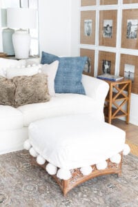 Corner of living room decorated in blue and white and fur throws.