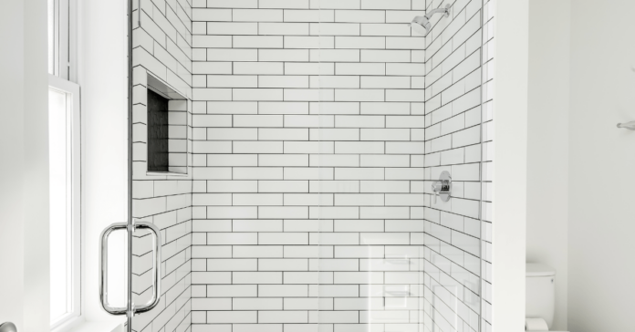 White subway tile shower with stainless steel fixtures.