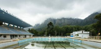 Photo of man standing in near-empty Newlands municipal swimming pool in Cape Town by Bloomberg via Getty Images